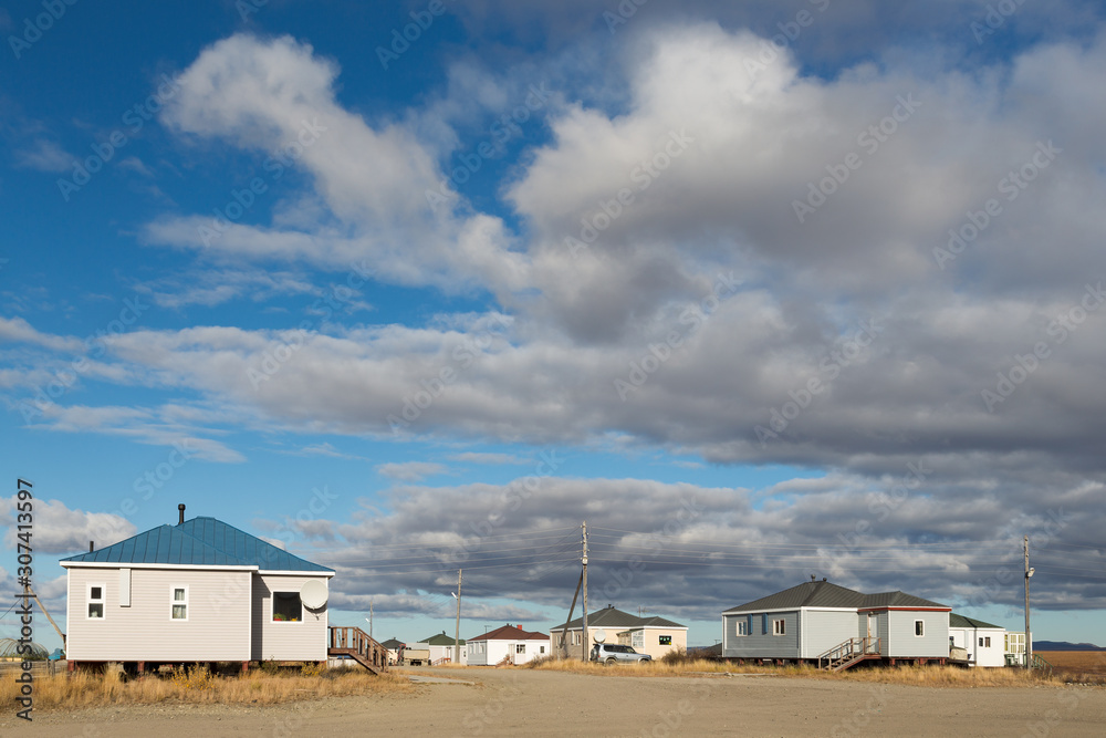 Chukchi village of Amguema. Rural settlement in the Arctic. View of the street and modern houses. There are clouds in the sky. Chukotka, Polar Siberia, the Far North of Russia.