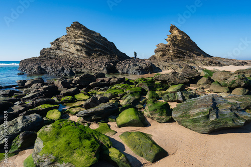 Woman on the rocks at Praia da Samoqueira beach in Portugal photo