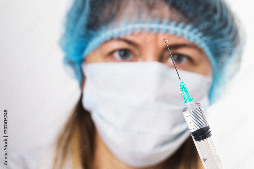 The doctor checks the syringe before injection, close-up The doctor checks the syringe before injection, close-up