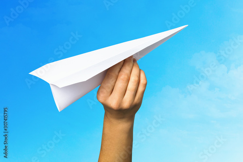 Concept on the topic of starting a new business and striving forward. Man launches a paper plane into the sky