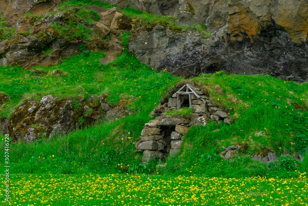 Dug in the green grass, the home of the Hobbits in Iceland. Traditional home Storage. Herbal roof. Journey around the island. The Landscape Of Iceland. Tourism.
