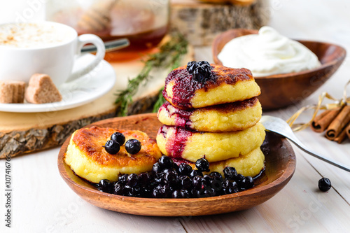 Fritters of cottage cheese with blueberries in plate, closeup