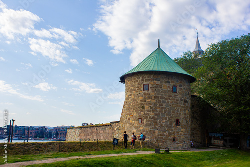 Canvas Print Old tower in downtown Oslo. Park with people
