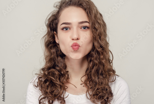 Tender young cheerful passionate caucasian girl with a light clean smile camera folded lips give love to everyone yellow background romantic flirty.