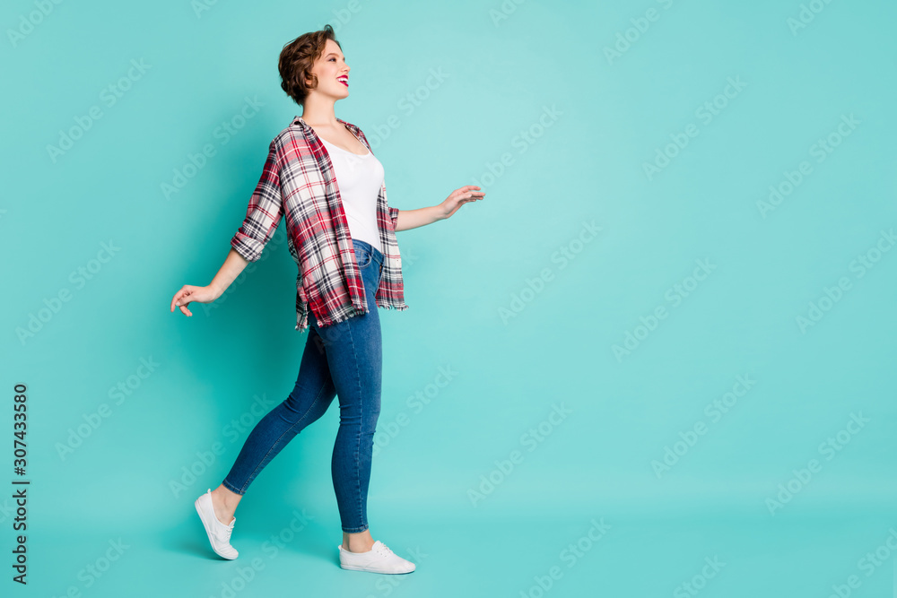 Full size photo of positive cheerful girl go walk enjoy spring free time wear stylish modern clothing isolated over turquoise color background Full size photo of positive cheerful girl go walk enjoy spring free time wear stylish modern clothing isolated over turquoise color background