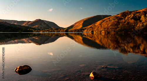 Fototapeta Naklejka Na Ścianę i Meble -  Grasmere Lake reflections in the Lake District in autumn. Sunset over beautiful still lake in Cumbria, England, UK.