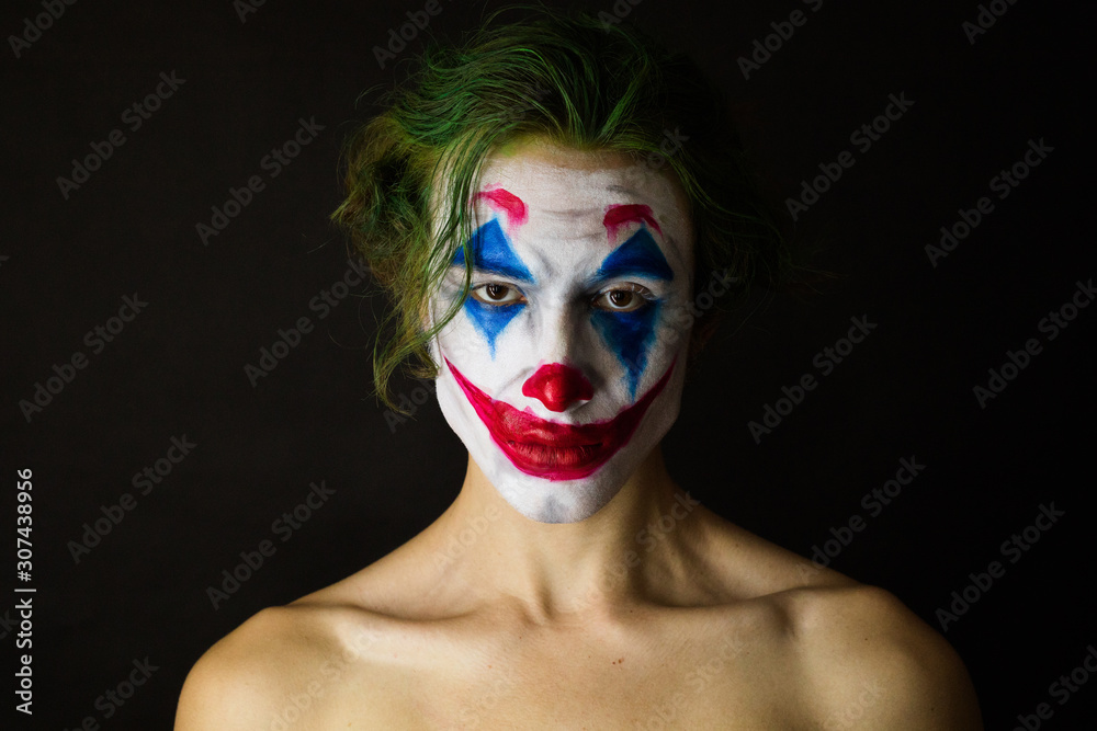 Portrait of a man with clown makeup and green hair, cosplay.