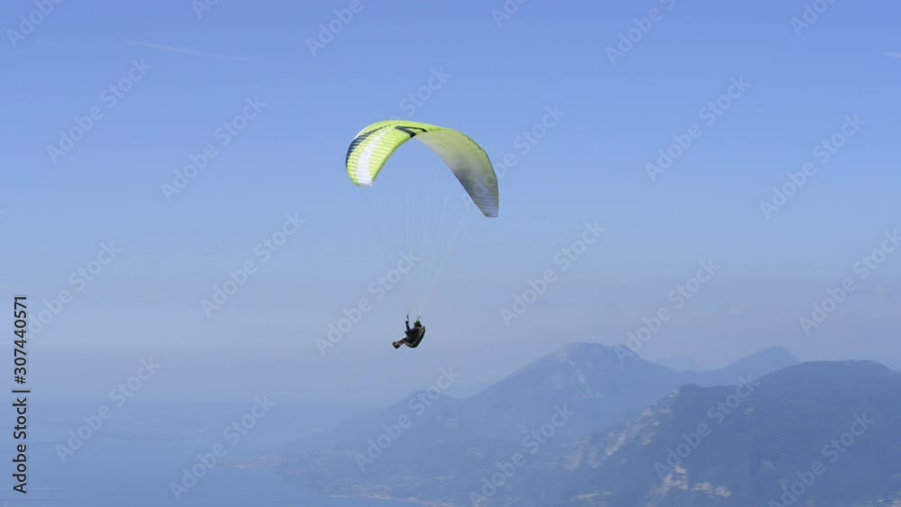 Paraglider flying over the Garda Lake (Lago di Garda) Panorama of the gorgeous Garda lake surrounded by mountains. Paragliding is very popular sport in Monte Baldo. Paraglider flying over the Garda Lake (Lago di Garda) Panorama of the gorgeous Garda lake surrounded by mountains. Paragliding is very popular sport in Monte Baldo.