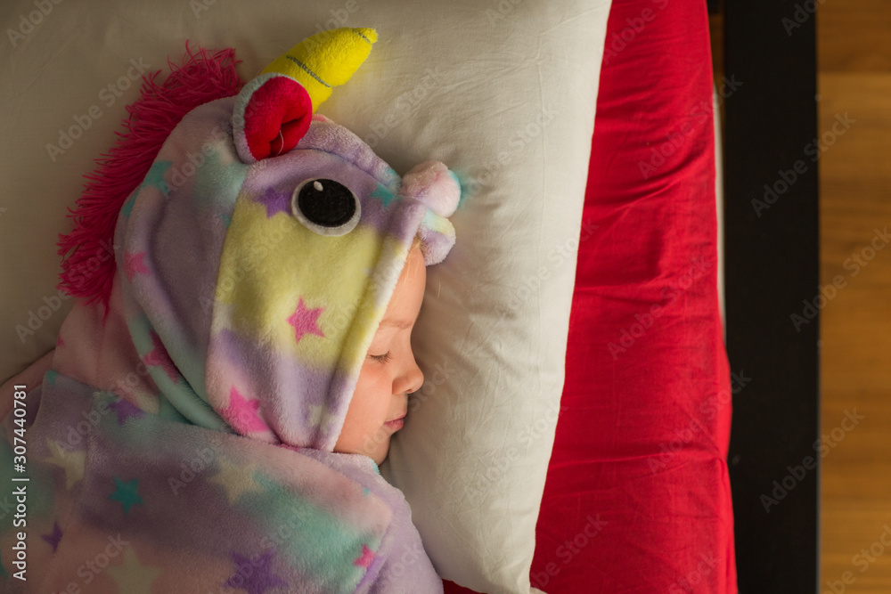 Girl in unicorn pajama sleeping in bed Stock Photo Adobe Stock