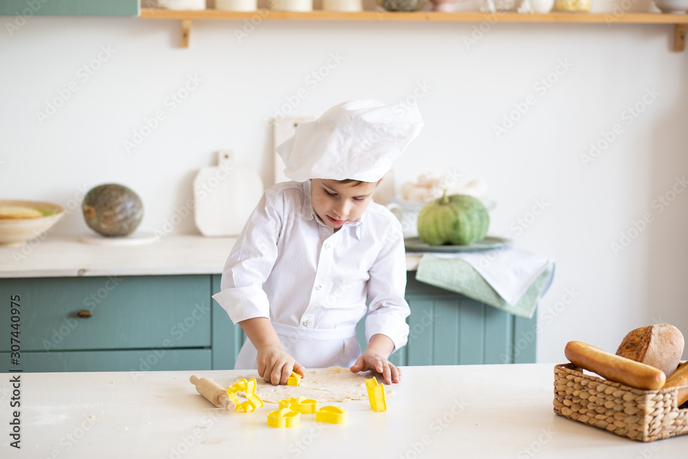 little child baking cookies in domestic kitchen.