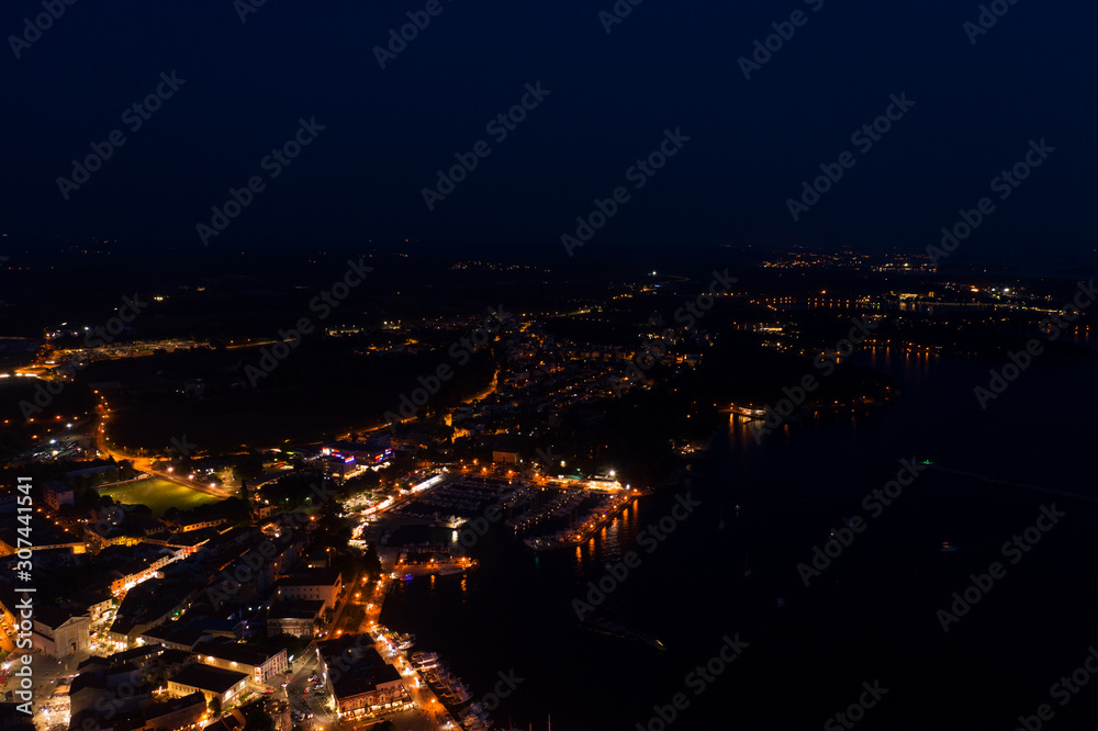 Night city on the coast of the sea. Top view. Shooting from a drone.