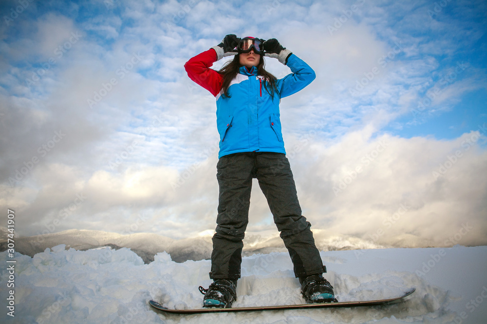 Young woman in winter mountains with snowboard, extreme sports.leisure activities