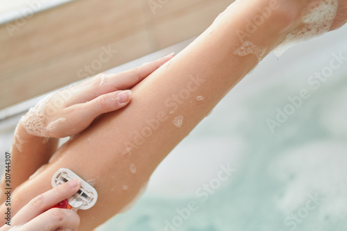 woman applying cream on her legs