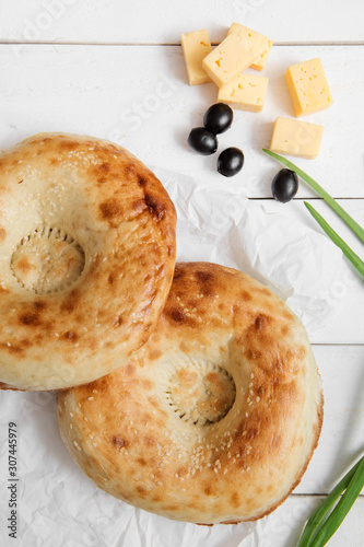 Bread and Bakery. Uzbek cuisine. The typical traditional uzbek round shape bread and green onion, olives and cheese on white background.