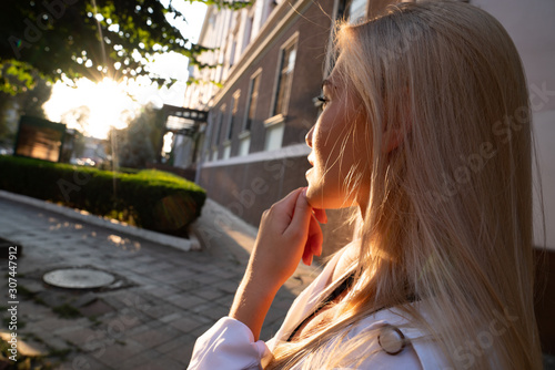 Side view portrait of a beautiful blonde girl with healthy skin that looking at the sunset