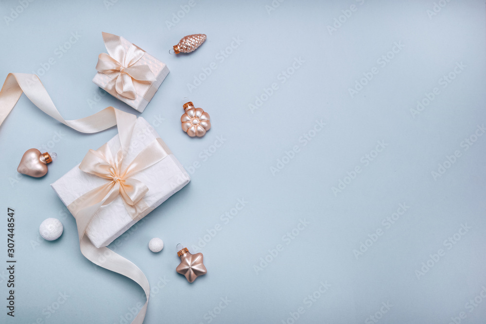 Christmas holiday composition, white gift boxes and golden Christmas toys on a light blue background. Minimalism, flat lay. Copy space Christmas holiday composition, white gift boxes and golden Christmas toys on a light blue background. Minimalism, flat lay. Copy space
