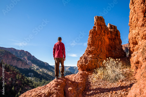 Hiker standing on cliff edge enjoying the view of the Utah desert near Parowan and Cedar City.
