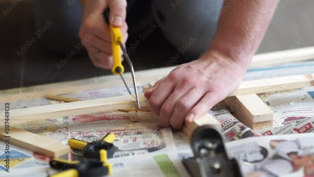 handyman, carpenter cutting piece of wood with handsaw and other tools handyman, carpenter cutting piece of wood with handsaw and other tools