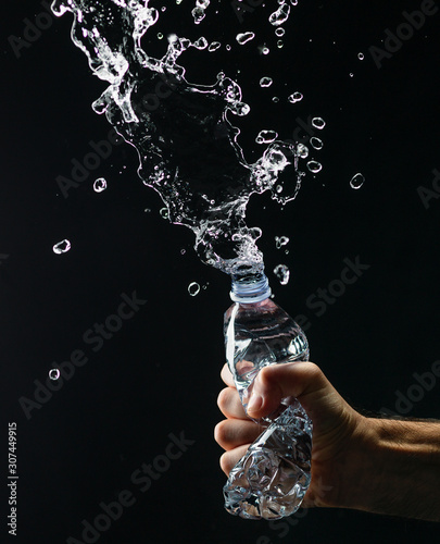 Hand crushing a water bottle