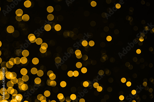Golden sparkles raster festive background. Bokeh lights with bright shiny effect illustration. Overlapping glowing and twinkling spots decorative backdrop. Abstract glittering circles.