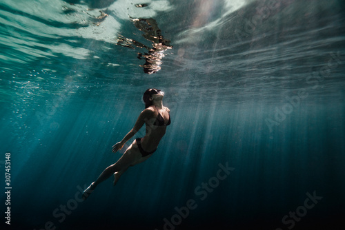 Woman swimming underwater in ocean