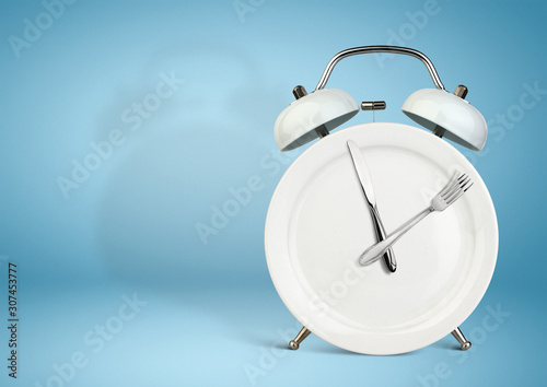 Concept of intermittent fasting, lunchtime, diet and weight loss. Plate as Alarm clock on blue
