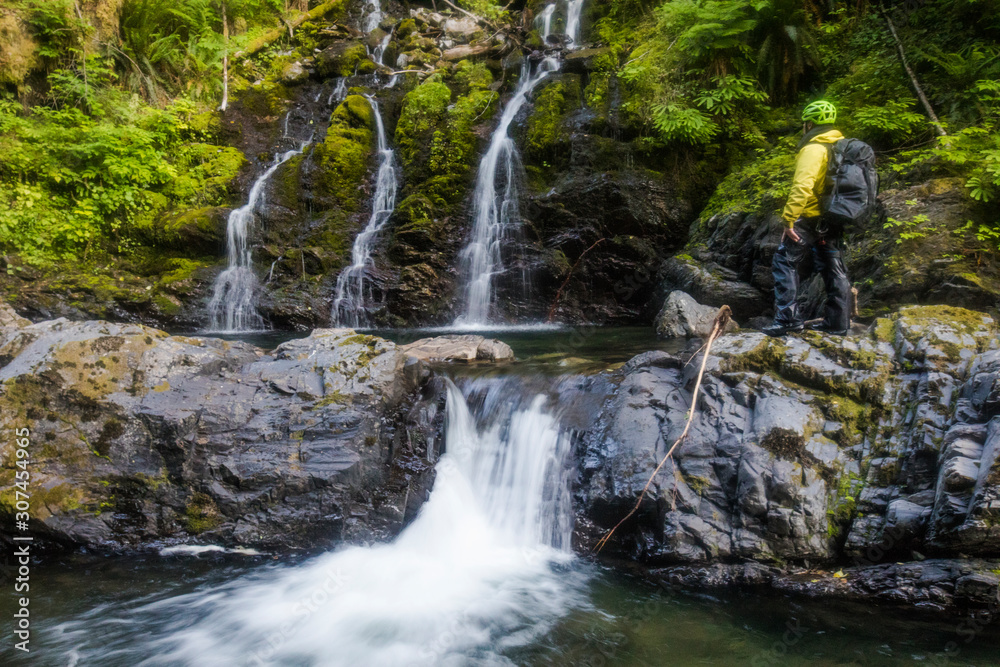 Hiker looks at waterfall in Frost Creek Canyon Hiker looks at waterfall in Frost Creek Canyon