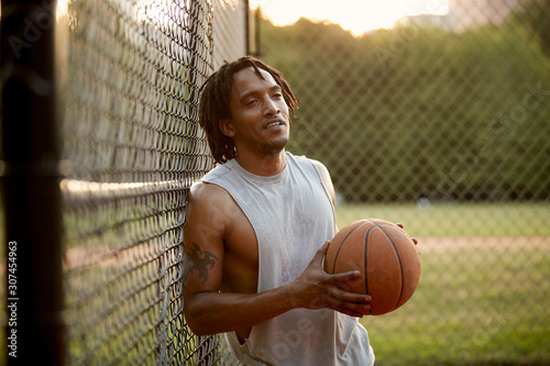 African-American man playing basketball outdoors photo