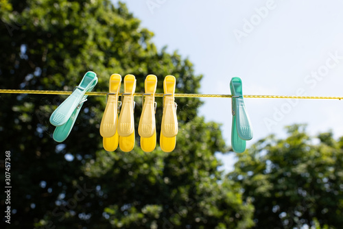 coloured pegs hanging on a washing line in an english country garden