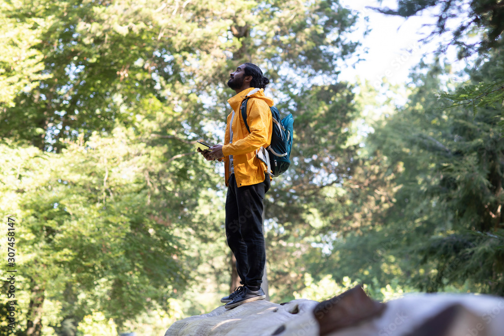 young hiker india relaxing and standing on a tree trunk young hiker india relaxing and standing on a tree trunk