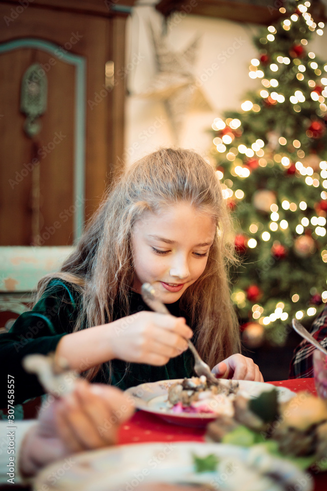 Little girl, teen daughter at a festive Christmas or New Year table. Little girl, teen daughter at a festive Christmas or New Year table.