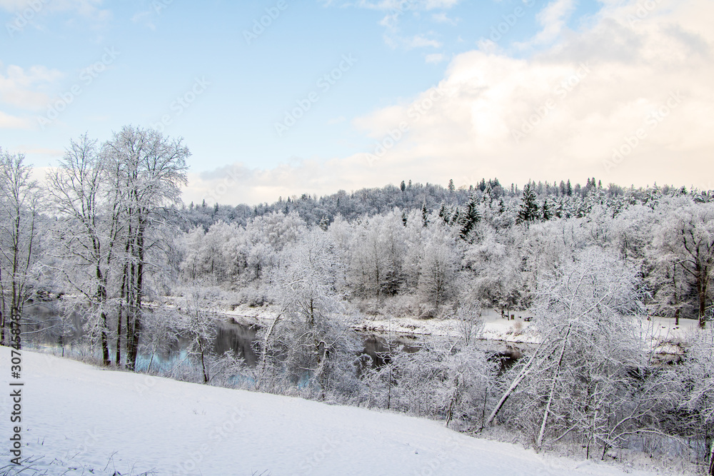 View to river Gauja in Gauja National Park with lot of snow and blue sky in December in Sigulda in Latvia