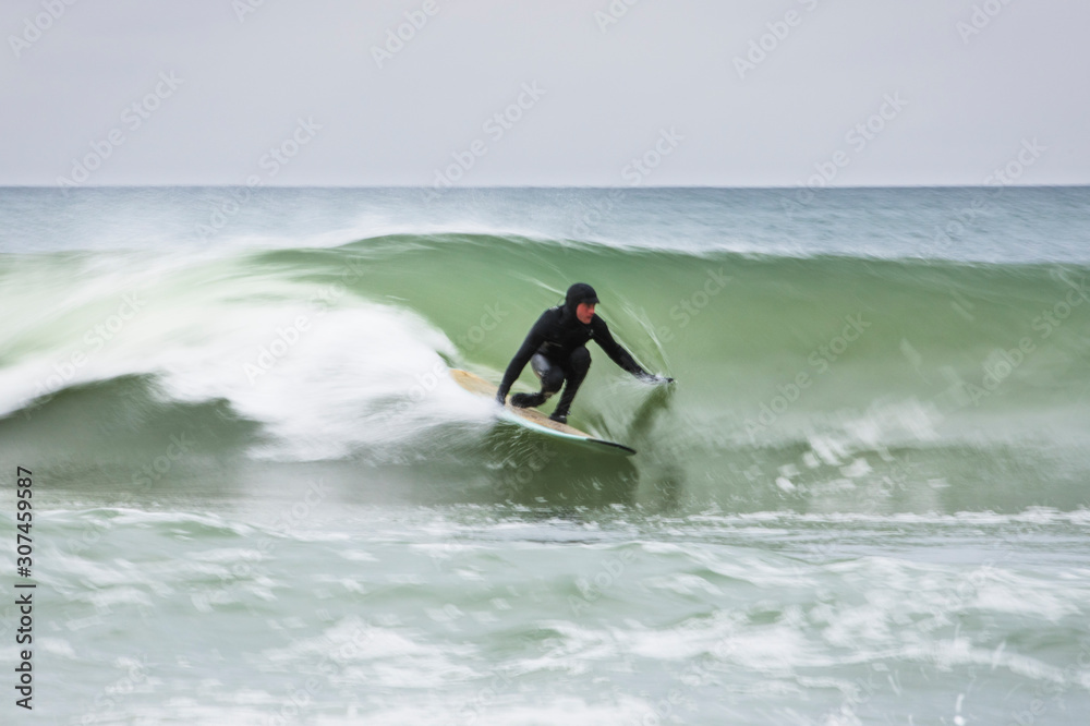 Motion blur of man surfing winter wave Motion blur of man surfing winter wave