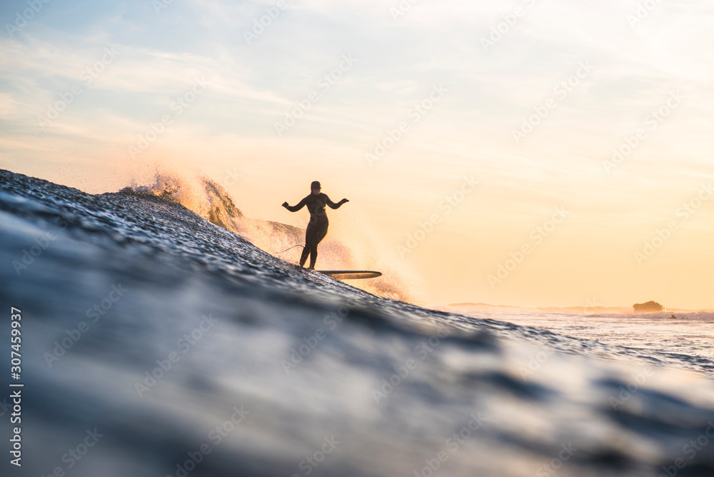 Woman enjoying golden hour winter surf Woman enjoying golden hour winter surf