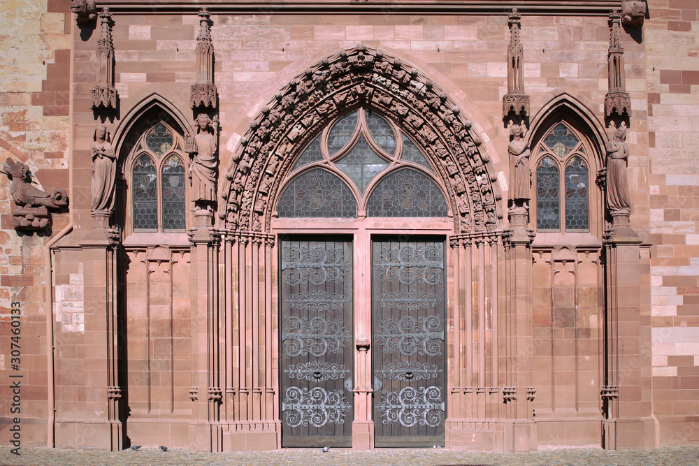 Front entrance of the Basel cathedral. Gothic style portal door, gothic tympanum, architectural detail, decorative reliefs of medieval cathedral. Switzerland