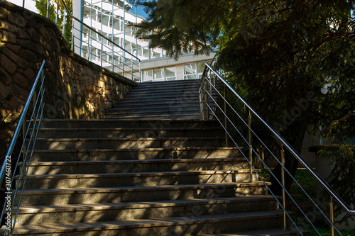 Fototapeta Naklejka Na Ścianę i Meble -  stone staircase, iron railing, Sunny day, shadows from trees