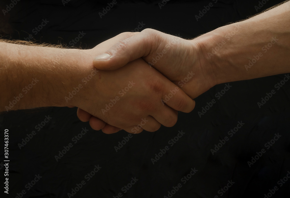 Hands shaking on the black background, Strong man hands. Del and congrats. Together. Hands shaking on the black background, Strong man hands. Del and congrats. Together.