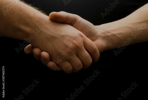 Fototapeta Naklejka Na Ścianę i Meble -  Hands shaking on the black background, Strong man hands. Del and congrats.  Together.