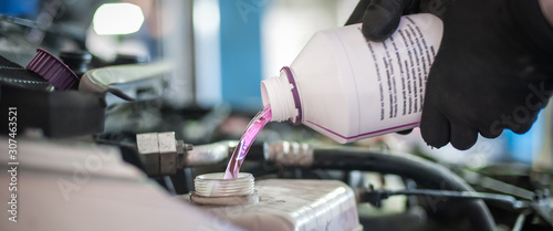 Auto mechanic pours antifreeze in the car
