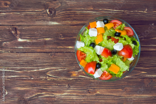 Fresh healthy greek salad on wooden table. View from above with copy space