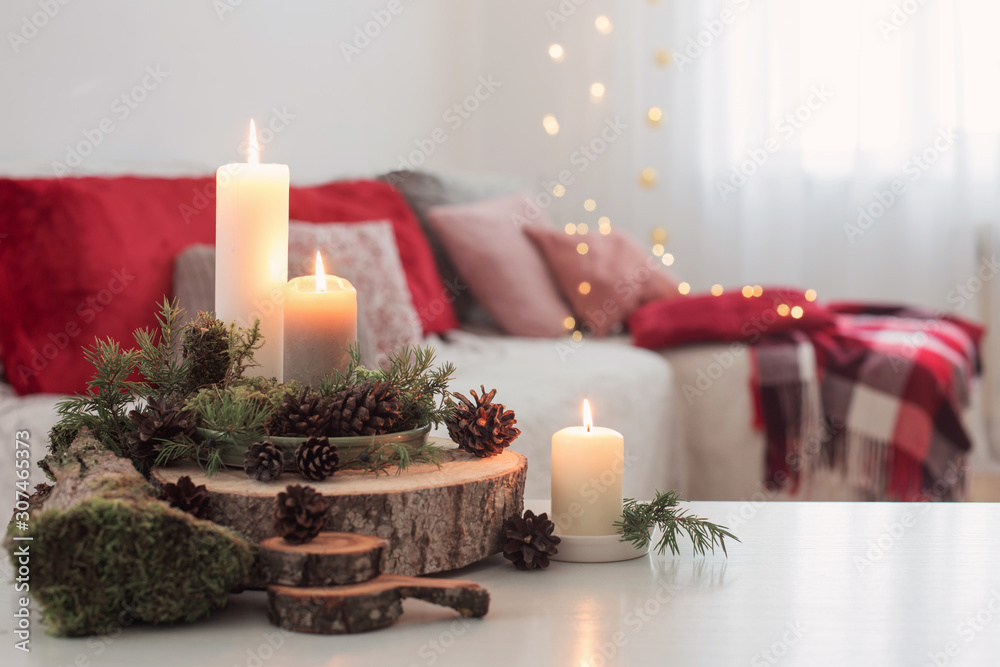 Composition of candles on white table against the background of sofa at home Composition of candles on white table against the background of sofa at home