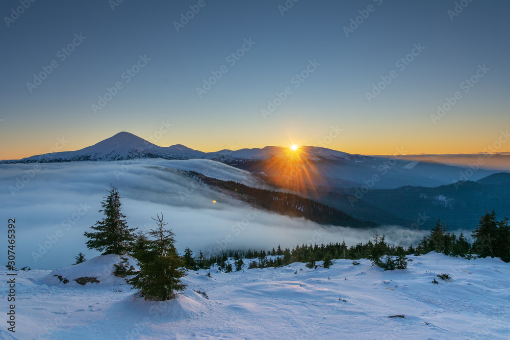 Winter camping high in the mountains, among the clouds and fog in the red tourist tent.