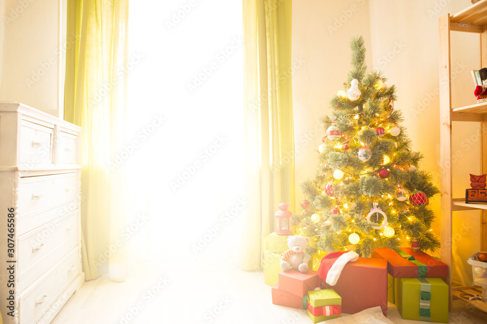 Christmas tree with gifts in a white room. Christmas morning