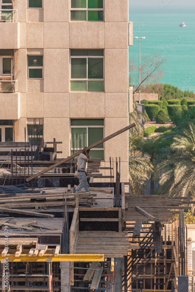 Obraz premium Construction worker working on a building site near sea