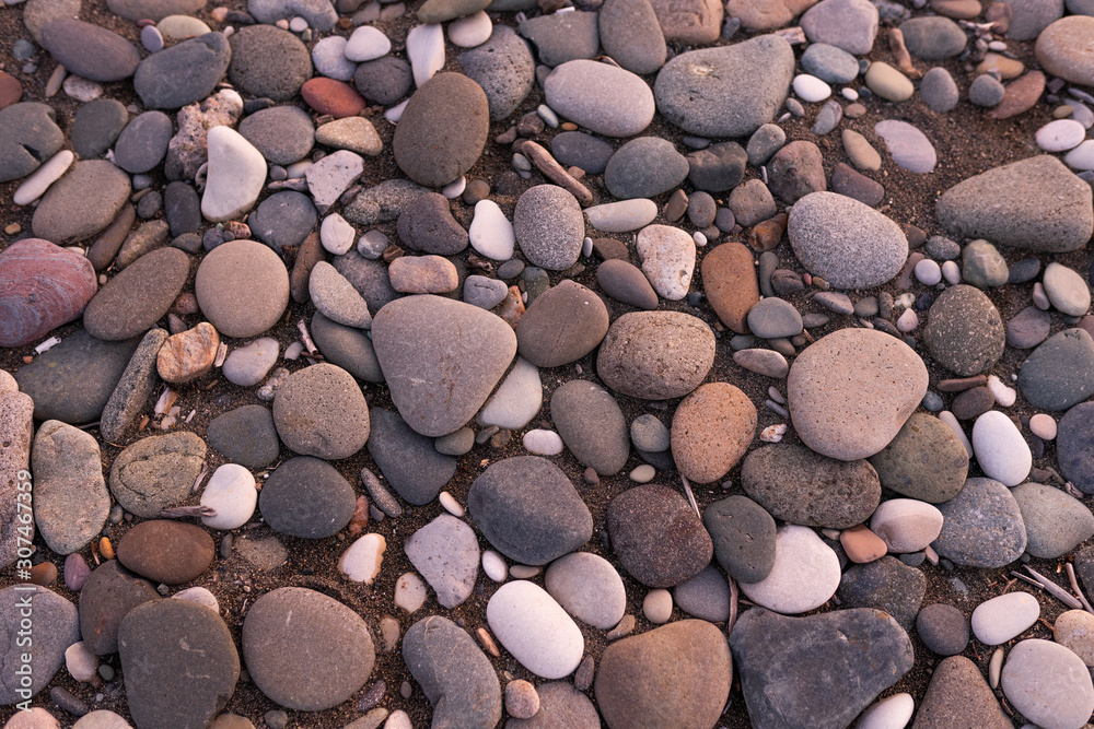 Large pebbles or stones lie on the shore at sunset. Black Sea Large pebbles or stones lie on the shore at sunset. Black Sea