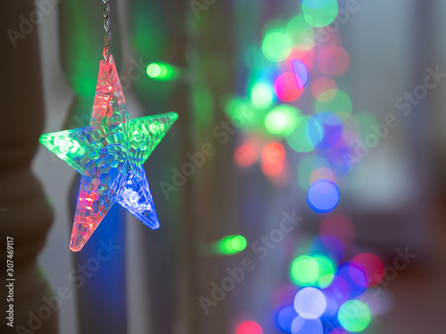 Christmas star-shaped LED garland hanging in a room . close up. bokeh