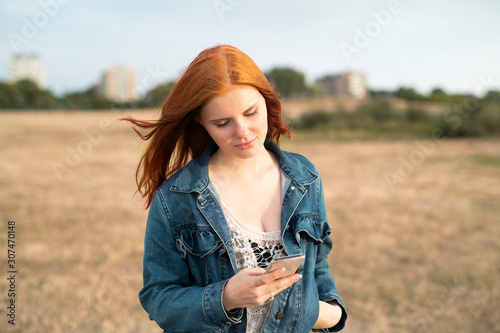 Red-haired woman with cell phone photo