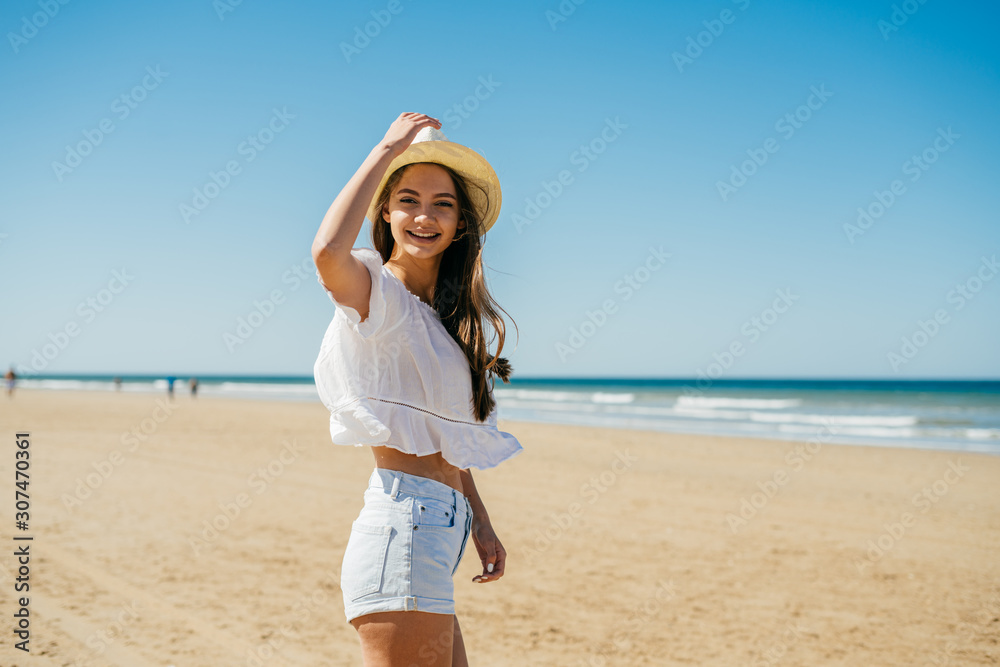 fashionable stylish girl in shorts, raising his hat waving his hand