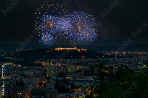 Brno Spilberk blue pyrotechnics brunensis. Year fireworks ignis celebration. Night sparkling city with illuminating buildings and castle Spilberg with dark sky on background.