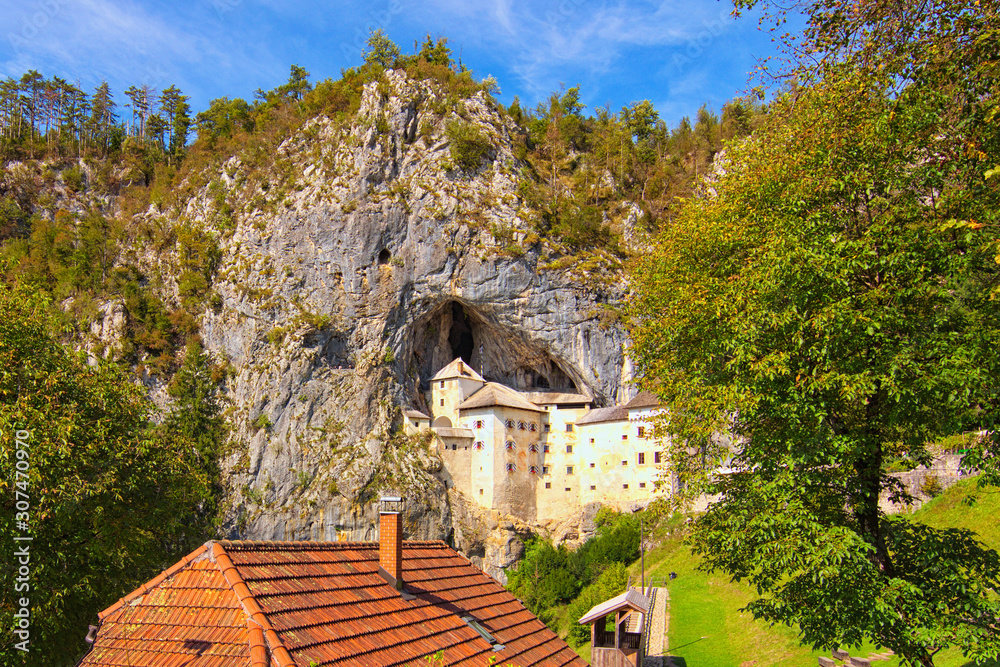 Landscape view of ancient castle in the cave. Predjama castle (Slovene. Predjamski grad). It is a Renaissance castle built within a cave mouth. First mentioned in 1274. Village of Predjama, Slovenia